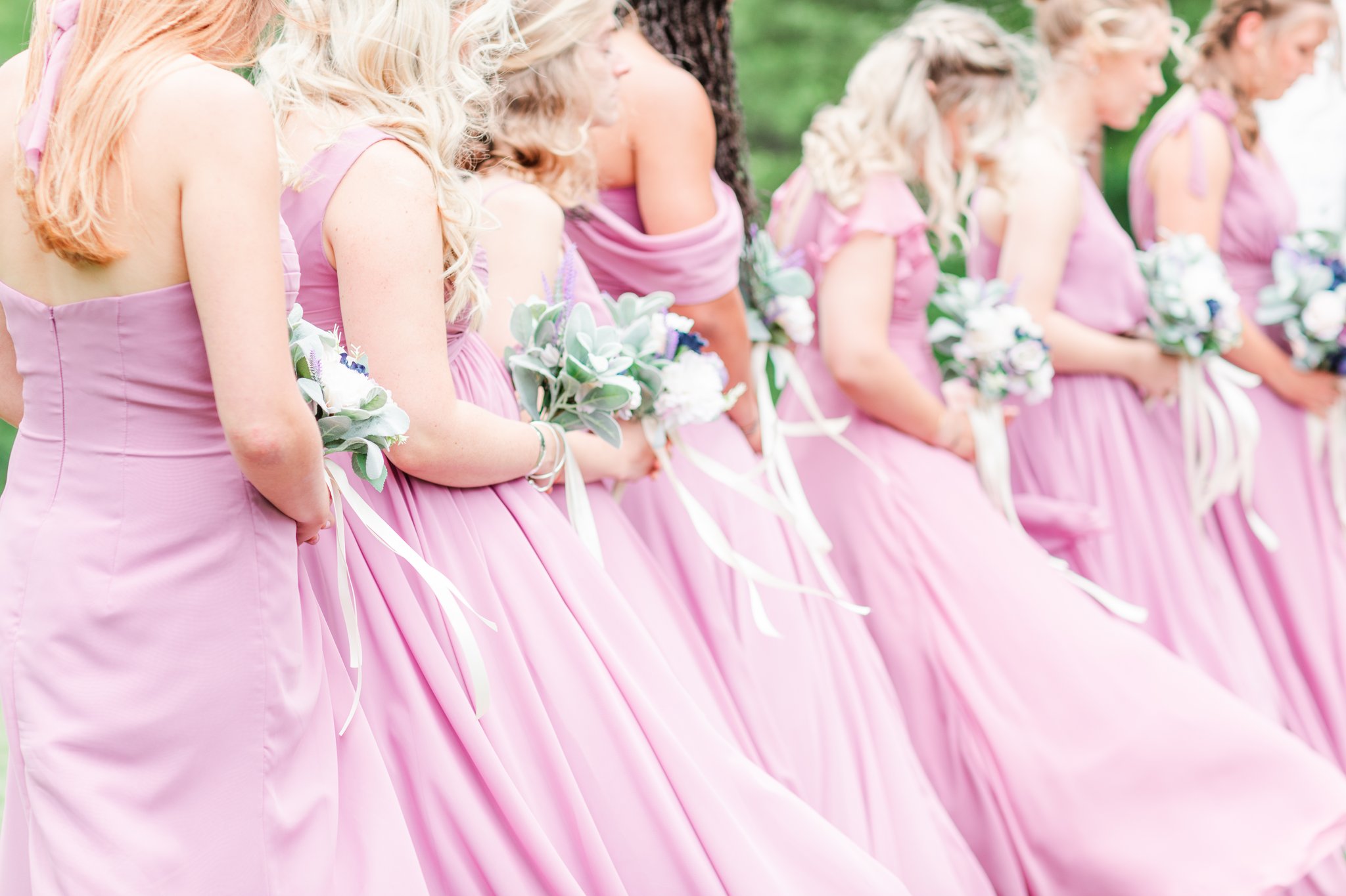 Bridesmaids lined up during wedding ceremony wearing wisteria bridesmaid dresses from JJ's house