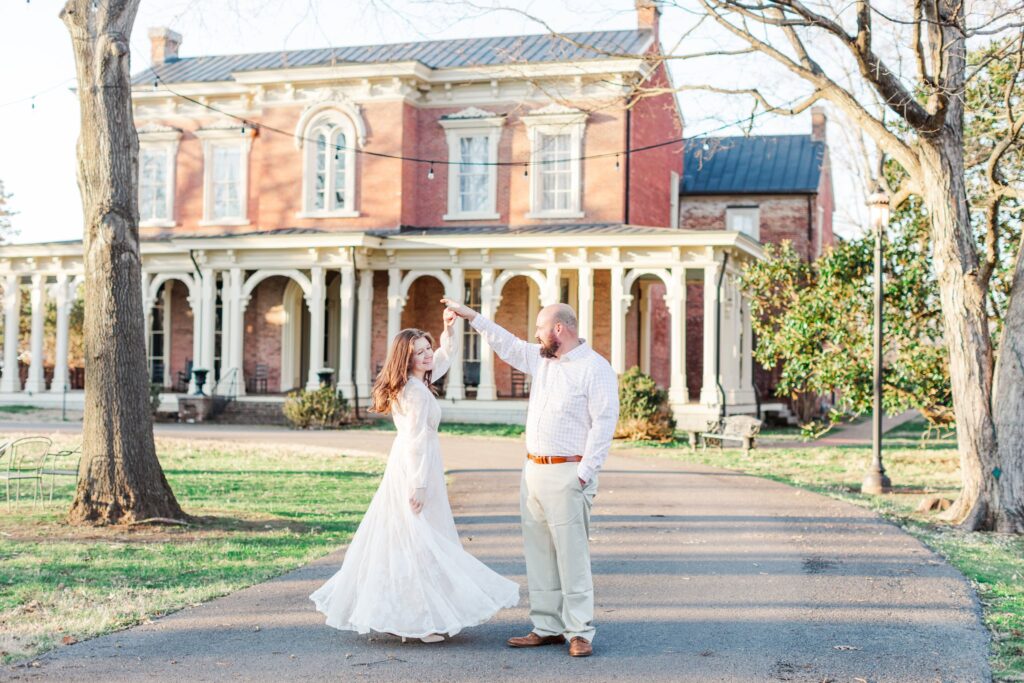 engaged couple spinning in front of Oaklands Mansion in Murfreesboro, TN