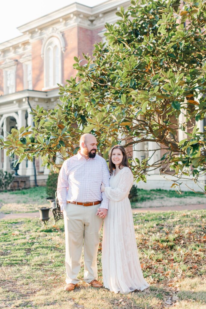 engaged couple smiling and standing outside of Oaklands Mansion just outside of Nashville, TN