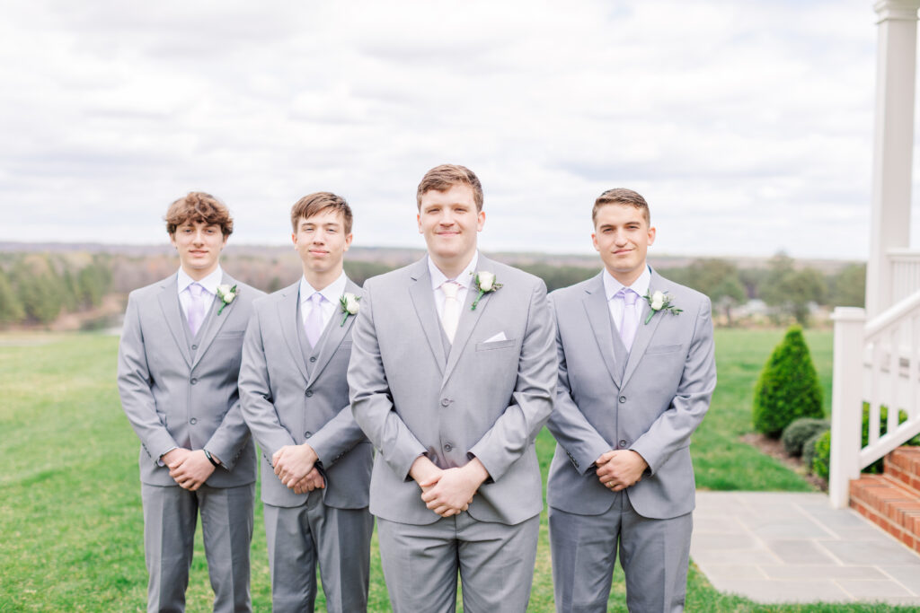 groom posing with his groomsmen on his wedding day with a beautiful view in the background