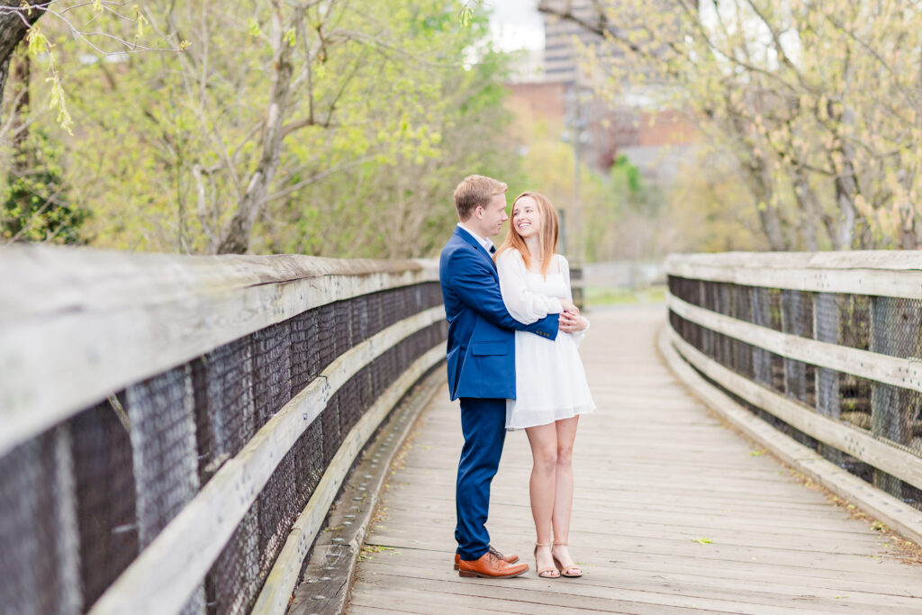 cute engaged couple smiling at each other at their Virginia Engagement Session on Percival's Island Bridge