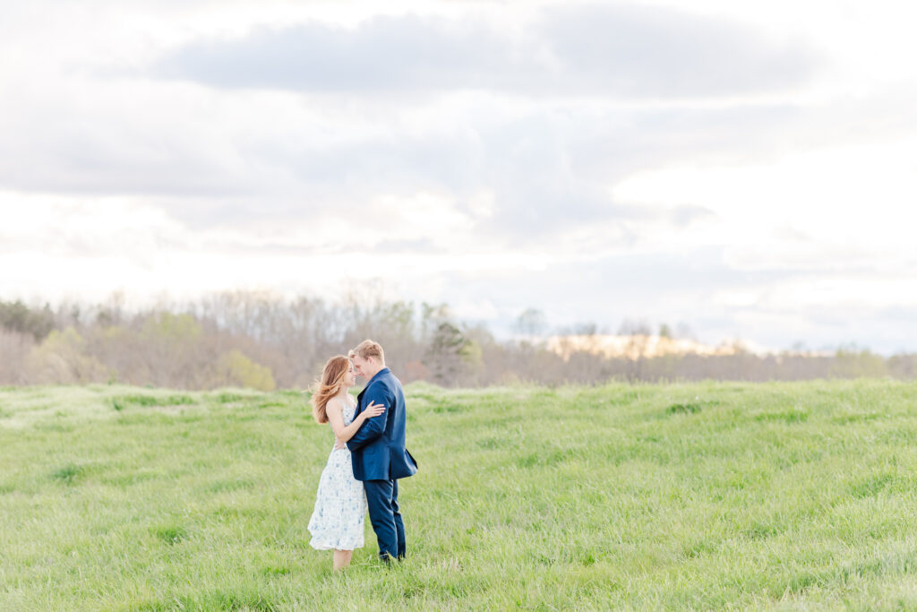 engaged couple laughing together in a field during sunset at Spring Grove Ranch during their Virginia Engagement Session