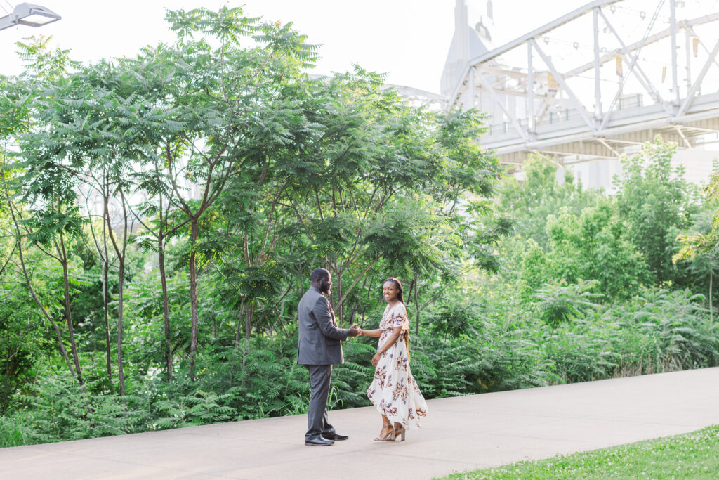 Engaged Couple twirling at Cumberland Park in Nashville. 