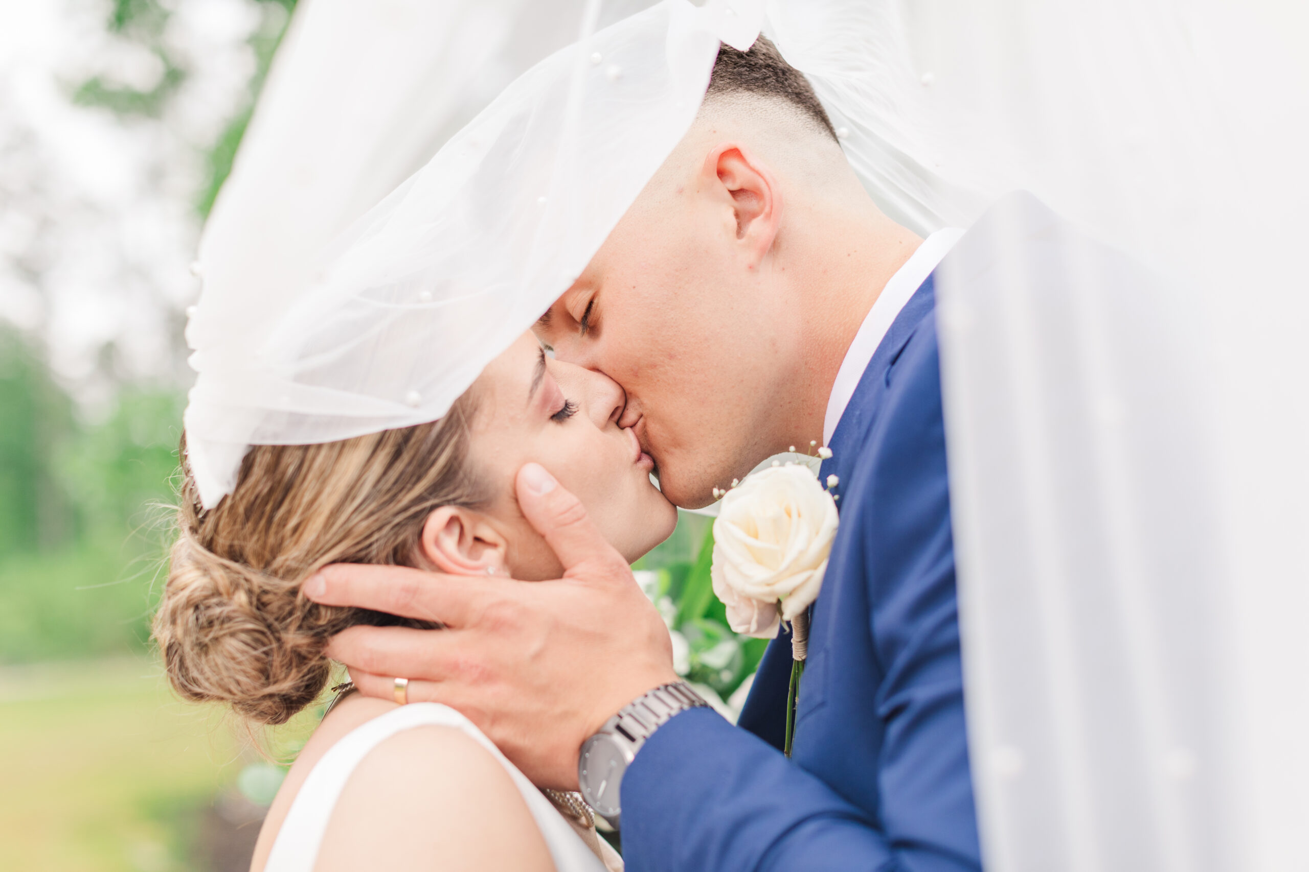 Bride and groom kissing underneath veil at their Timberlee Farm Wedding