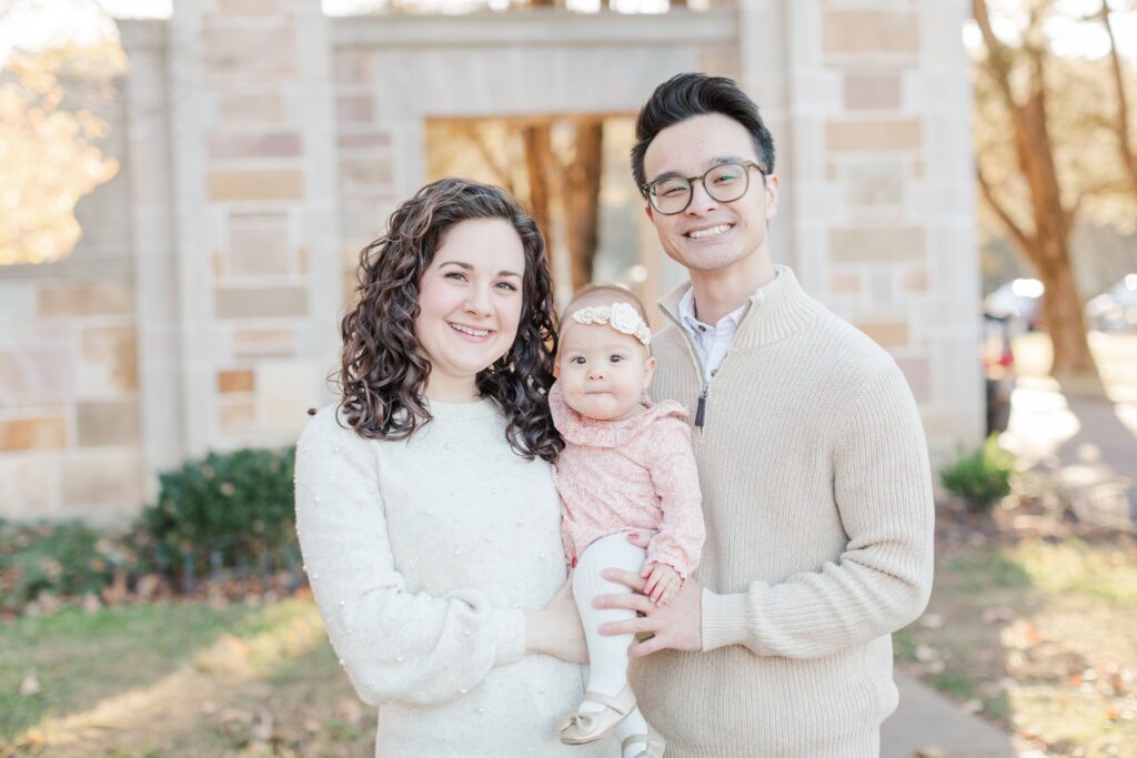 Mother and father holding child while smiling at Percy Warner Steps