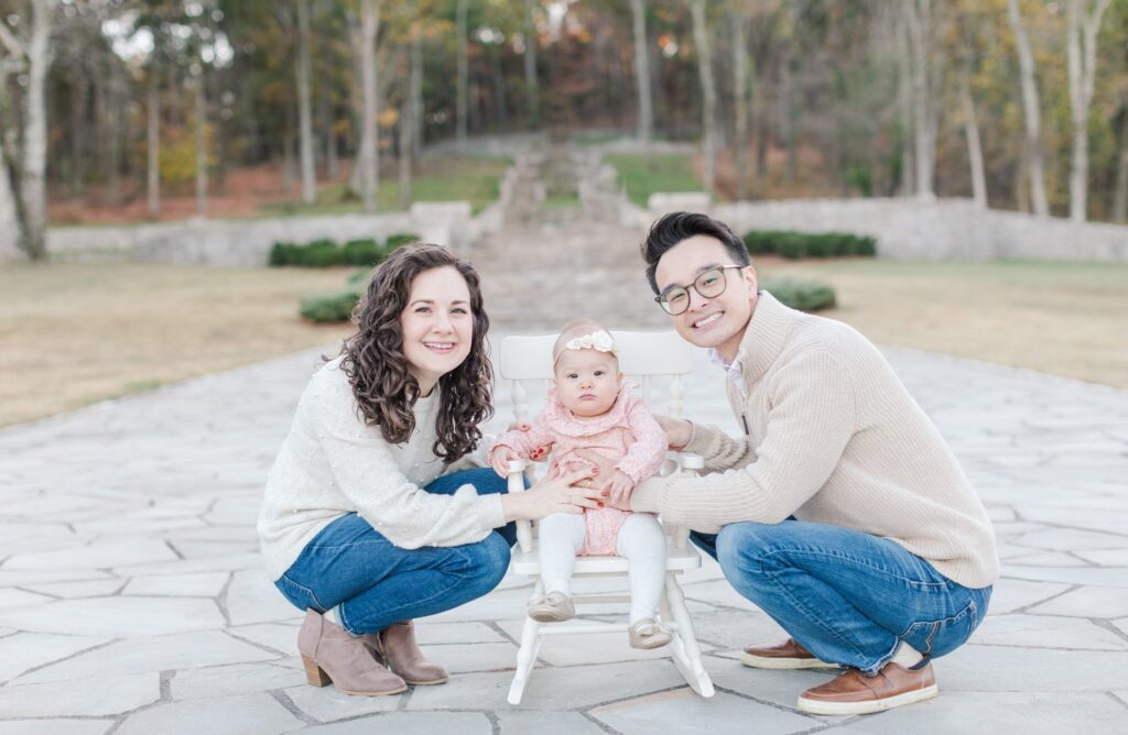 Mom and dad and child smiling at camera together at Percy Warner Steps