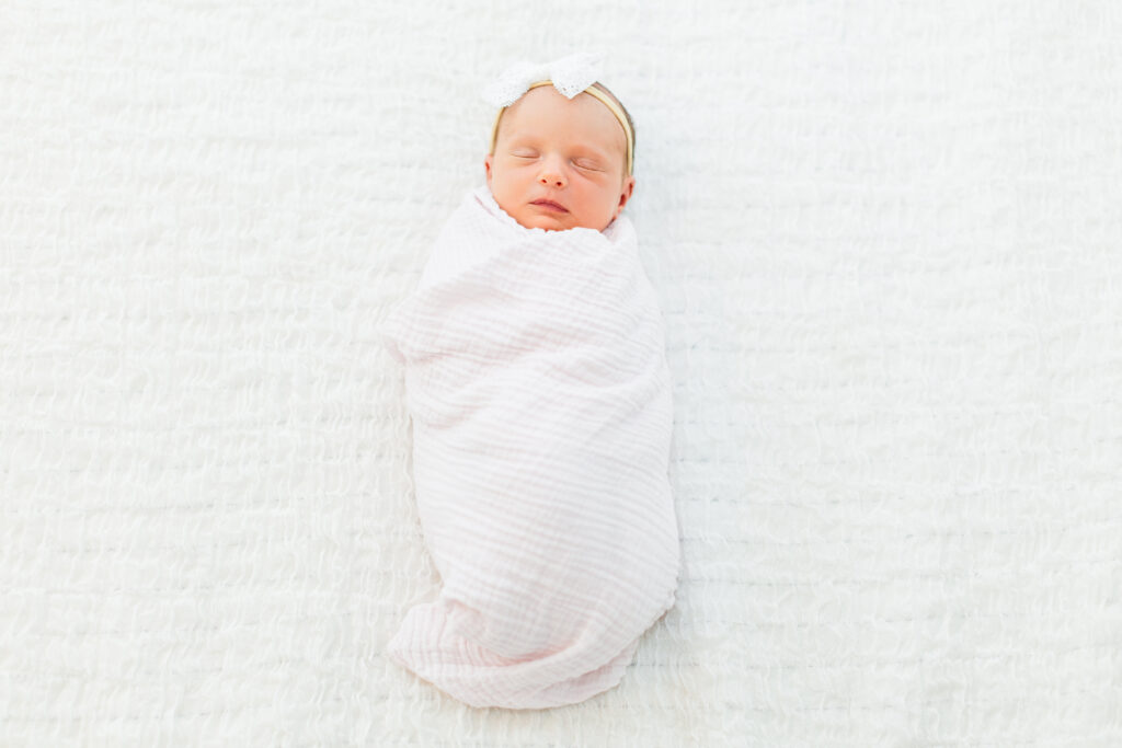 Newborn baby swaddled in a pink blanket