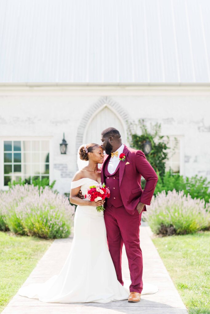 groom kissing his bride on her forehead on their wedding day