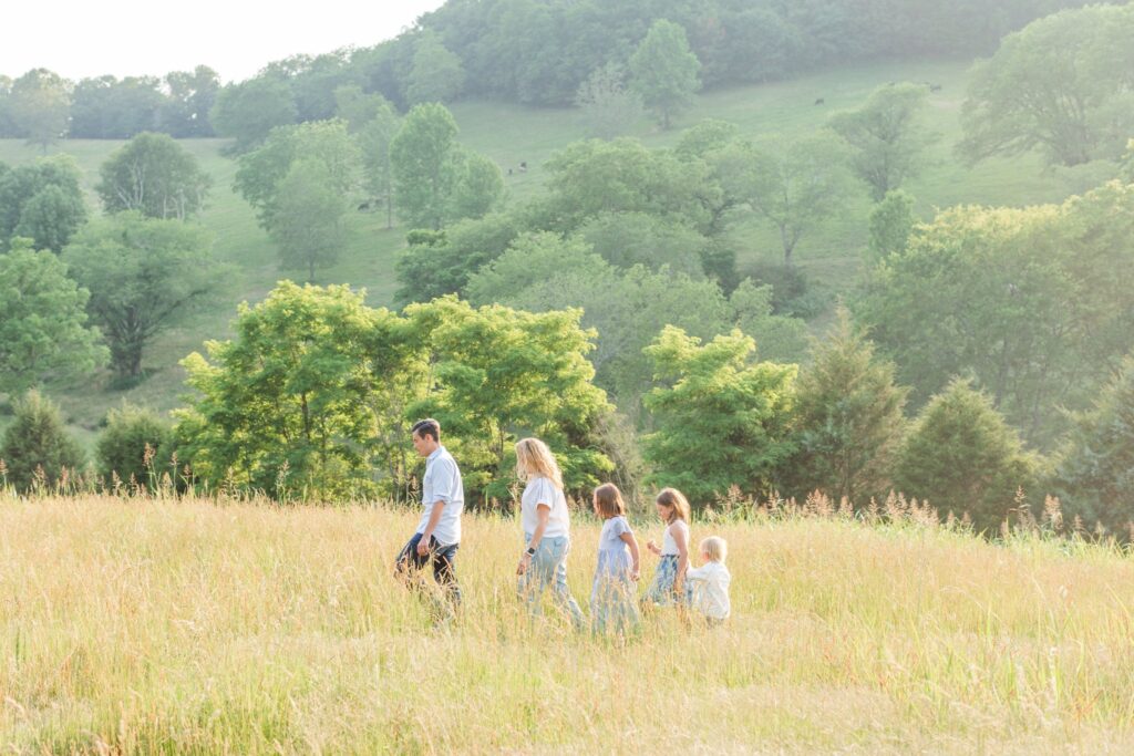 family of five walking in a bright, summer field in Tennessee, hire the right family photographer