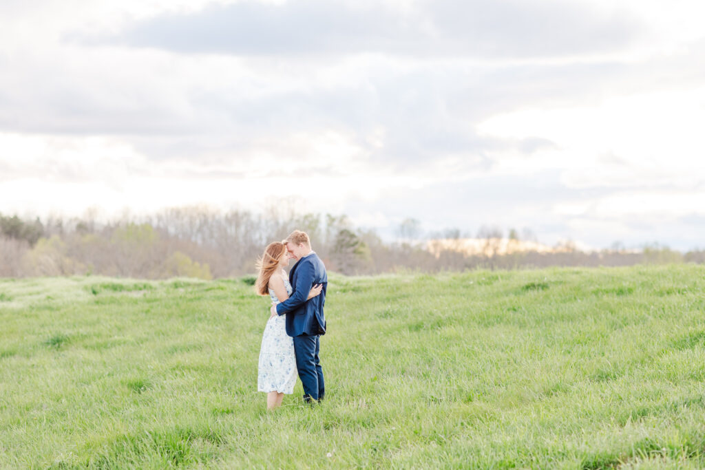 Engaged couple in a field during golden hour, How to Pick a Wedding Photographer