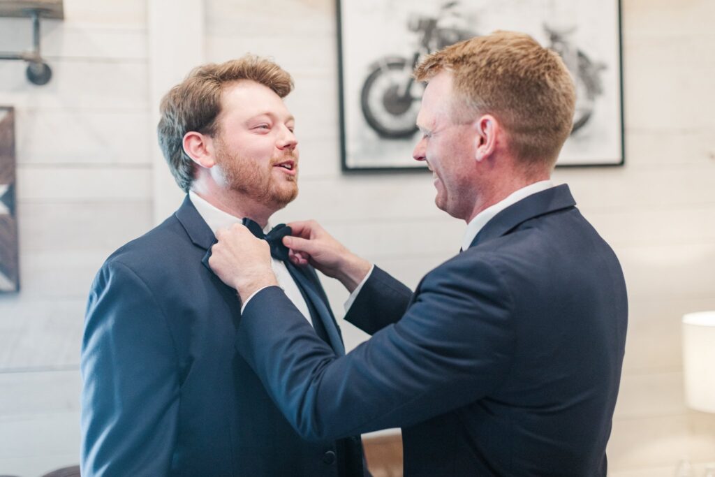 Best man helping groom in the groom's suite at the White Dove Barn in Beechgrove, TN