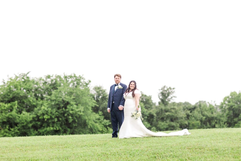 Husband and wife strolling along the rolling hills of White Dove Barn