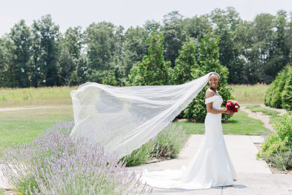 Beautiful bride standing by lavender growing outside Howe Farms